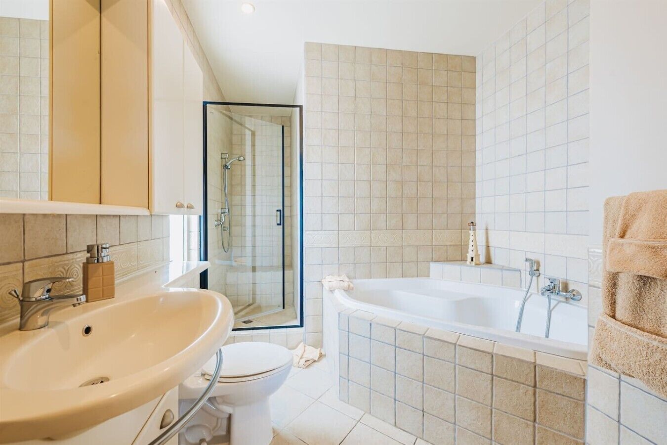 Ein modernes Badezimmer mit einer großen Badewanne, einer separaten Duschkabine und einem WC.