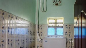 Un baño con baldosas estampadas, una ventana y un lavamanos blanco.