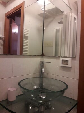 A bathroom with a glass sink, a mirror, and a wooden-framed window. - Casa sant'Apollonia (Sant'Apollonia)