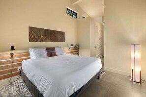A modern bedroom with a large bed, a wooden headboard, a wall-mounted light, and a window. - 4BR, Hot Tub, Firepit, Fireplace, Pet Friendly (Cle Elum)