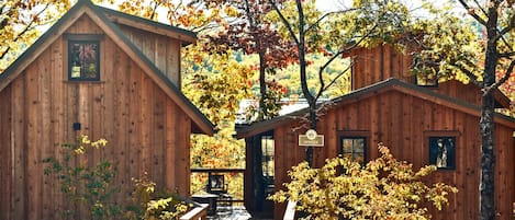 Une cabane en bois avec une véranda, une petite table et des chaises.
