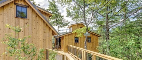 Una cabaña de madera con terraza y un pequeño porche.