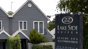 A grey building with a sign for Lake Side Suites, a luxury spa, and accommodation bookings. - Amazing Vacation Rental with Lake Views in Daylesford, Victoria (Daylesford)