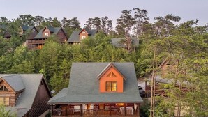 Un chalet doté de plusieurs cabanes, chacune ayant son propre balcon et étant entouré d’une forêt dense.