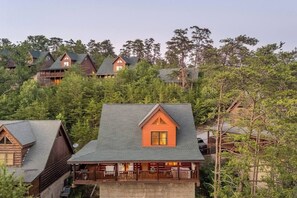 Eine Lodge mit mehreren Ferienhäusern, jedes mit einem Balkon und von dichtem Wald umgeben.