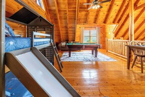 A wooden interior with bunk beds, a pool table, and a ceiling fan. - Mtn Views! Hot tub! 2 Pools! Mini Golf! Family fun (Sevierville)