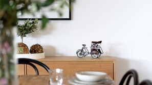 A dining table with plates, a glass, and a wooden cabinet with decorative items.