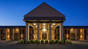 Ein mehrstöckiges Hotel mit überdachter Eingangspartie, mehreren Balkonen und einer Ziegel-Fassade.