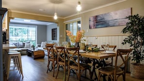 A dining area with a wooden table set for four, surrounded by wooden chairs. - Cozy, Pet Friendly Cabin with Fireplace in Daylesford, Victoria (Daylesford)
