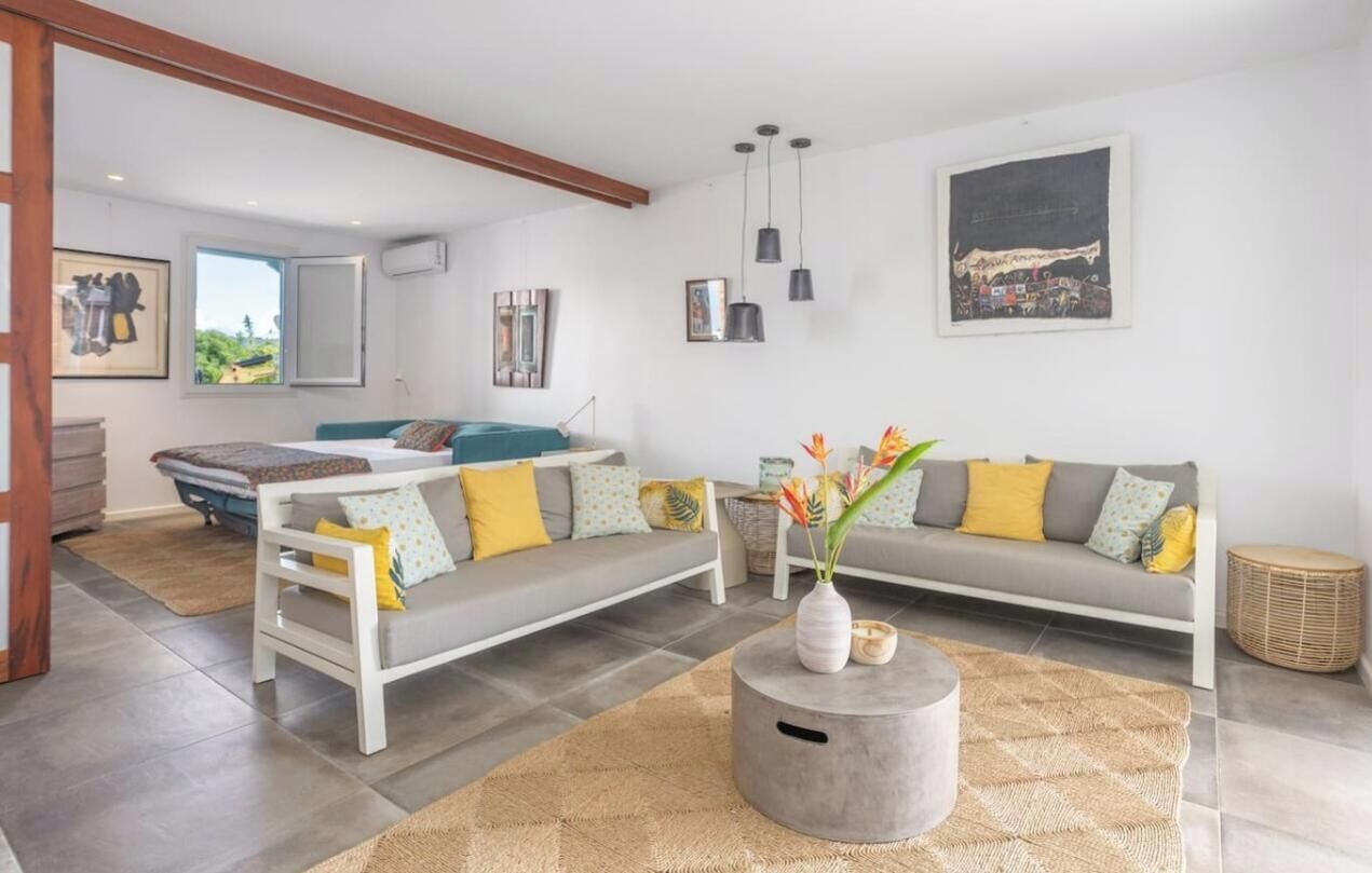 A modern living room with a sofa, a coffee table, and artwork on the walls.
