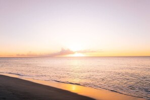 Ein Strand mit ruhiger See und blauem Himmel.