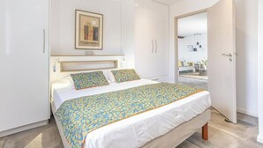 Ein Schlafzimmer mit einem Bett, einem Kleiderschrank und einer Tür zu einem anderen Raum.