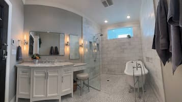 Une salle de bain avec un grand meuble-lavabo, une douche et une baignoire.