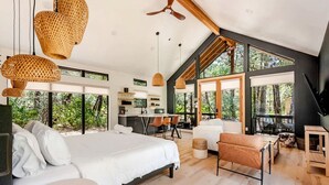 Ein modernes Schlafzimmer mit einem großen Bett, einem Schreibtisch und einer Sitzecke.