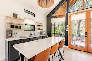 A modern kitchen with a large island, built-in appliances, and a view of the outdoors.