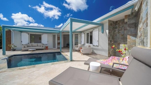 A poolside area with a covered seating area, a lounge chair, and a small table. - An Ti Doucè—Villa with a pool, 300 meters from the beach (Sainte-Luce)