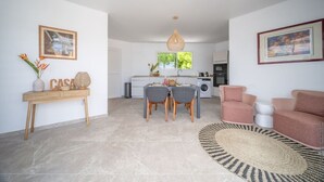 A modern living room with a dining area, a kitchen in the background, and a sofa set. - An Ti Doucè—Villa with a pool, 300 meters from the beach (Sainte-Luce)