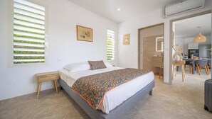 A bedroom with a bed, bedside tables, a desk, and a chair. - An Ti Doucè—Villa with a pool, 300 meters from the beach (Sainte-Luce)