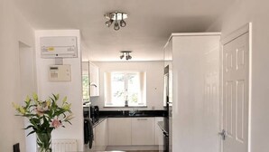 Une cuisine moderne dotée d’un îlot central, d’un coin repas avec une table et des chaises, et offrant une vue sur l’espace de vie adjacent.