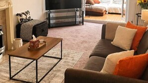 Un salon avec un canapé, une table basse, une cheminée et un téléviseur.