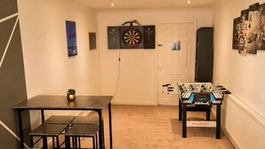 Une pièce équipée d’un baby-foot, d’un jeu de fléchettes et d’une table de billard.