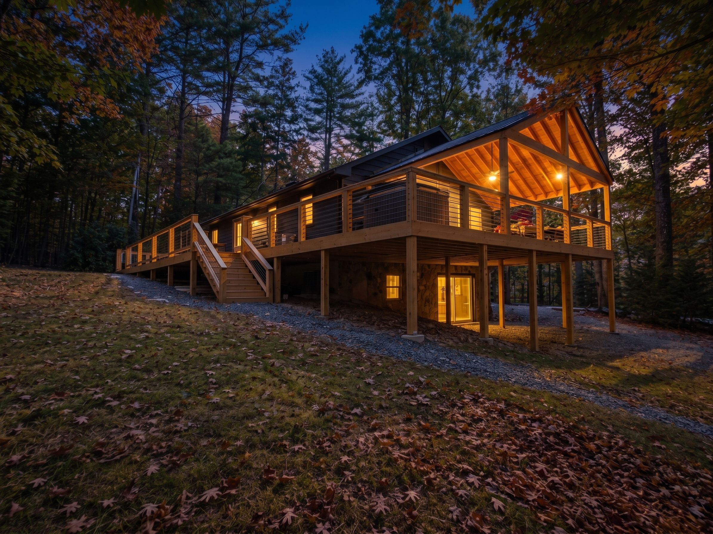 Eine zweistöckige Holzhütte mit überdachter Veranda und einer Treppe, die zum oberen Stockwerk führt.