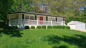 A single-story house with a front porch, a red door, and a small attached garage. - Peaceful 3-bedroom house in delightful Clarkson (Clarkson)