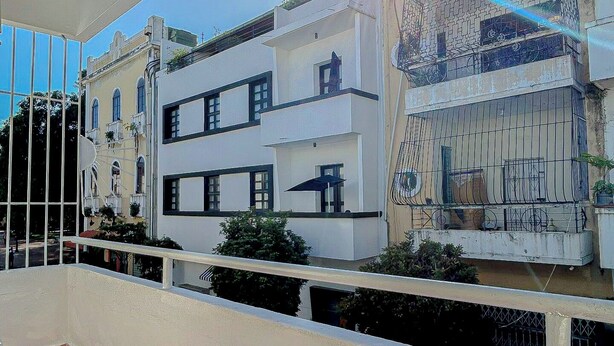 A modern building with a balcony, large windows, and a clear sky. - Room-twin Bed Room-king Room Zona Coloni (Santo Domingo)