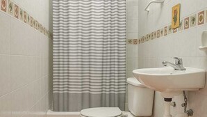A bathroom with a toilet, sink, and shower curtain. - Room-twin Bed Room-king Room Zona Coloni (Santo Domingo)