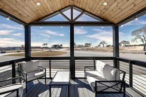 A covered outdoor seating area with a view of a road and buildings. - Charming and Modern Tiny Home Escape with Resort Amenities and Pool Near Fredericksburg, TX (Fredericksburg)