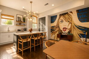 A modern kitchen with a central island, wooden chairs, and a dining table. - NEW! Nashville Era Nights & Rooftop Dreams (Nashville)