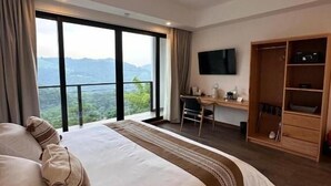 Una habitación de hotel con una cama grande, un escritorio, un televisor y un armario.