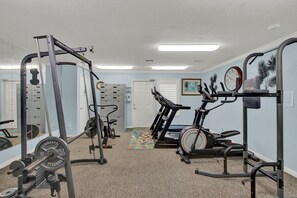 A home gym with a treadmill, weight bench, and various exercise equipment. - King Bed + Private Garage + Patio | Pool (Galveston)