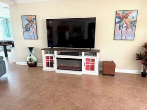 A living room with a flat-screen TV, fireplace, and decorative vases. - Deep Water Canal with 20' Floating Dock and Game Room (Crystal River)