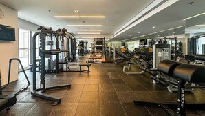 A gym with various exercise equipment, including weight machines and free weights. - 1B Walk to Metro, Marina Mall with Skyline Views (Dubai)