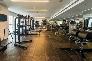 A gym with various exercise equipment, including weight machines and free weights. - 1B Walk to Metro, Marina Mall with Skyline Views (Dubai)