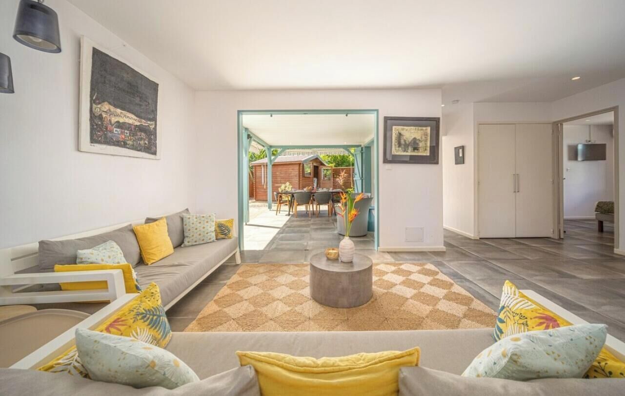Una sala de estar moderna con sofá, mesa de centro y vista al área de comedor.