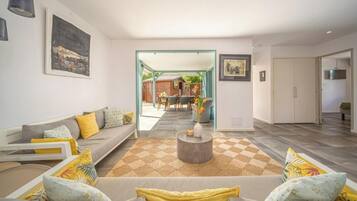 Una sala de estar moderna con sofá, mesa de centro y vista al área de comedor.