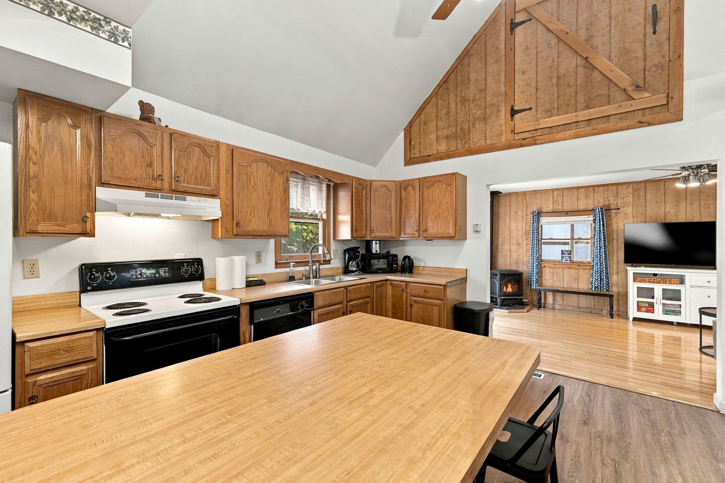 Une cuisine moderne avec des meubles en bois, un îlot central et une cuisinière intégrée.