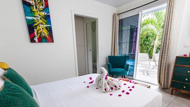 Ein Hotelzimmer mit einem Bett, einem schwanenförmigen Handtuch und einem Bild an der Wand.