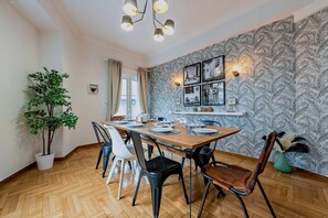 A dining area with a wooden table, chairs, and a potted plant. - Acropolis Oasis | Designer Home by the Acropolis (Athina)