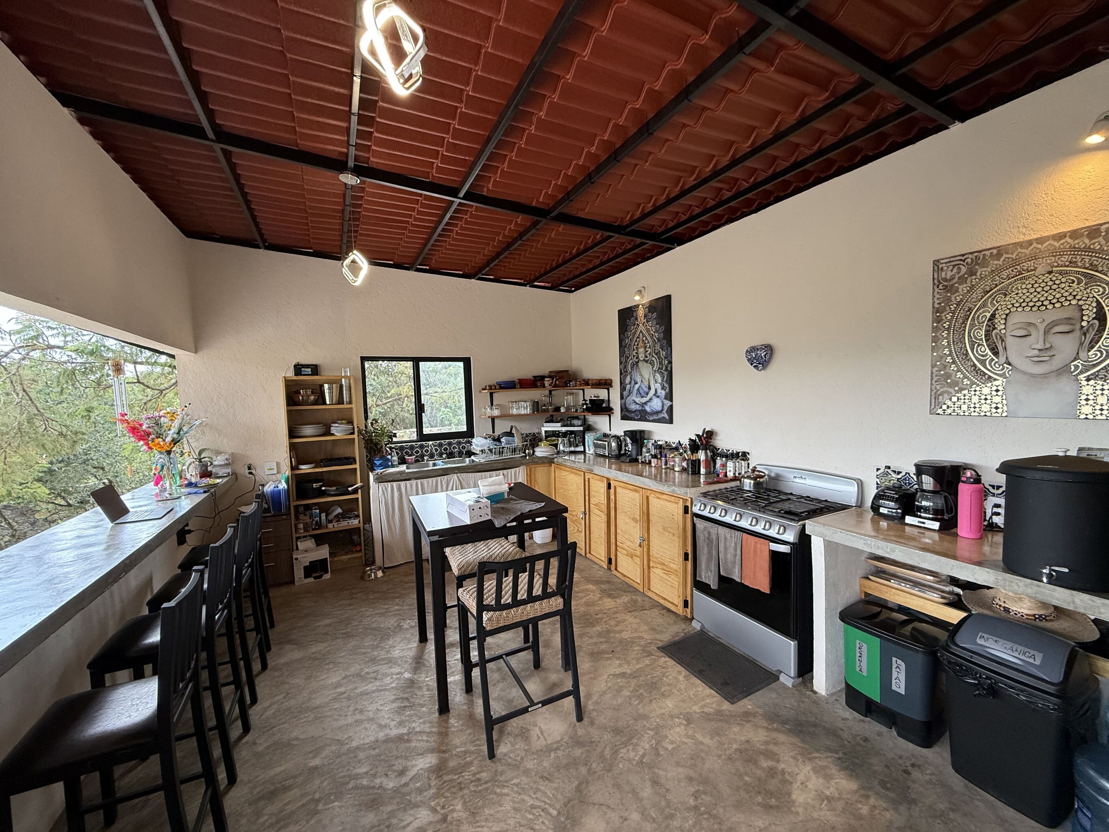 Une cuisine moderne avec un coin bar, une table à manger et des chaises.