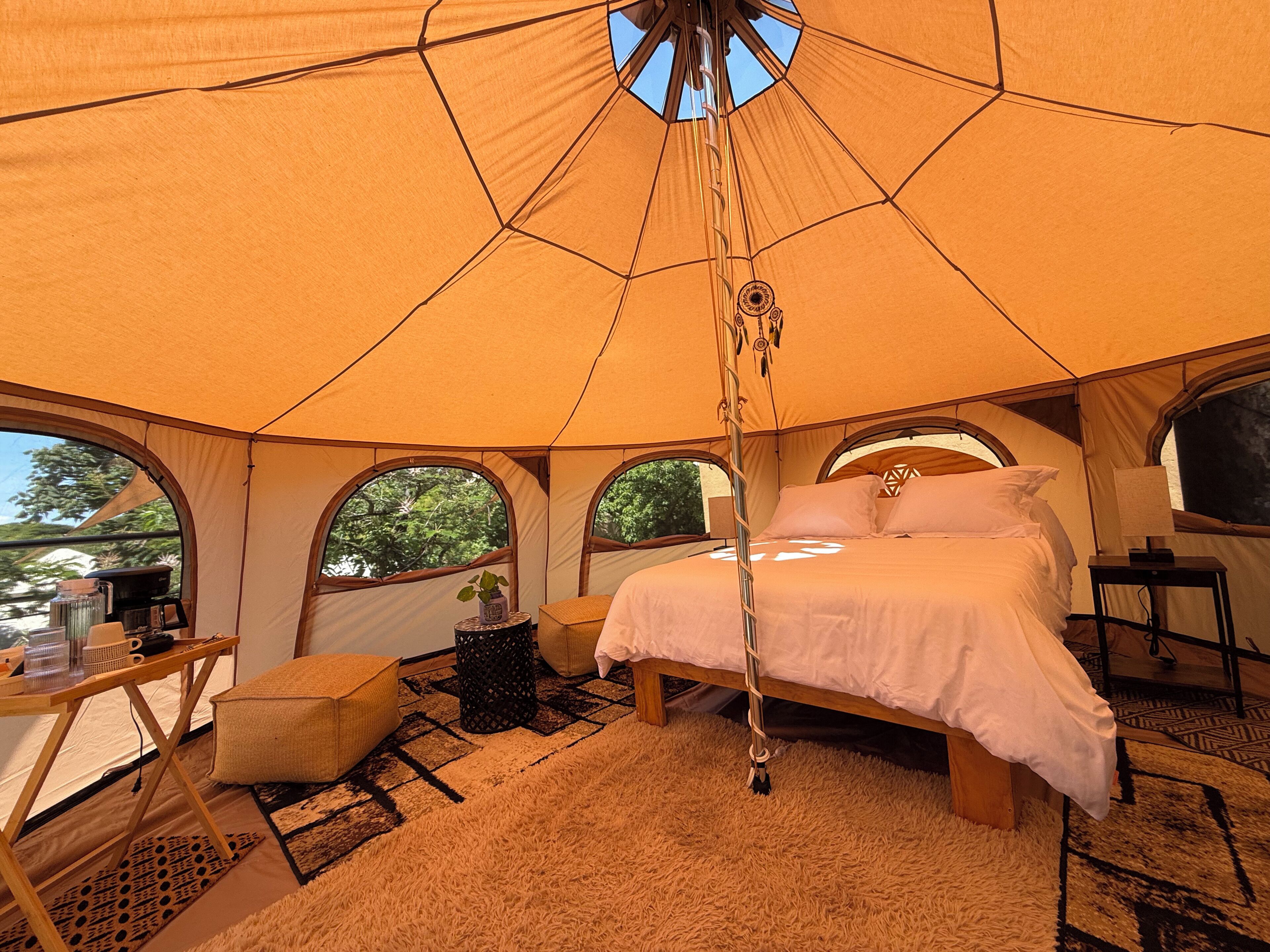 Ein Zelt mit Bett, Tisch und Stuhl.