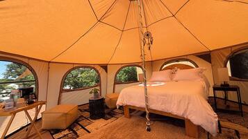 Ein Zelt mit Bett, Tisch und Stuhl.