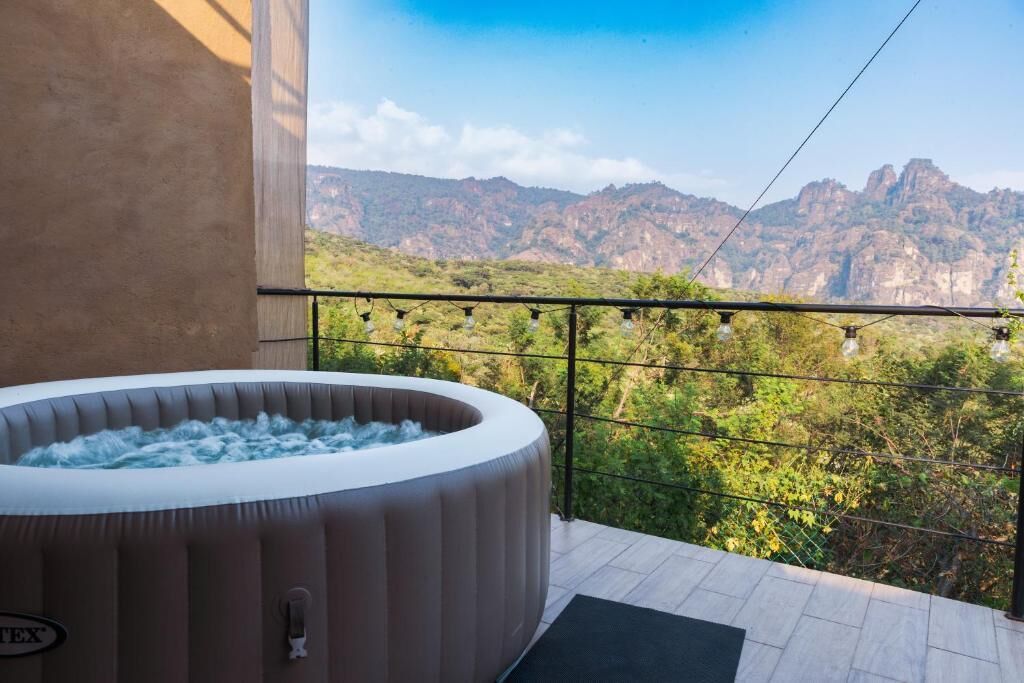 Un jacuzzi en un balcón con vistas a la montaña.
