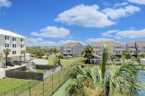 A residential area with multiple apartment buildings, a fenced playground, and a swimming pool. - Barrier Dunes 542 - 55 - Relax N' Moore (Port St. Joe)