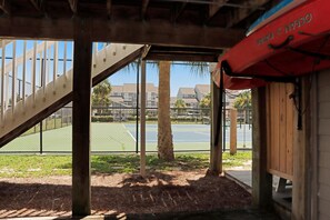 A covered outdoor area with a wooden staircase leading to a tennis court. - Barrier Dunes 542 - 55 - Relax N' Moore (Port St. Joe)