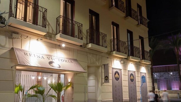 Eine Hotelscheune mit einem Schild, auf dem 'REINA VICTORIA' steht, und einem verschlossenen Eingang.