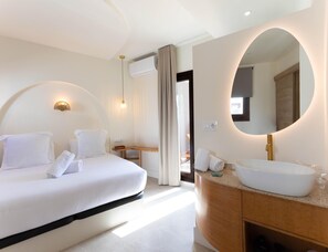 Ein Hotelzimmer mit einem Bett, einem Schminktisch mit großem Spiegel und einem Schreibtisch.