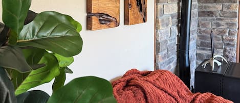 A room with a stone wall, a fireplace, and four wooden art pieces on the wall.